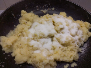 Adding sugar to semolina in a pan