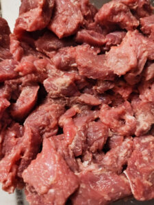 Beef coated with flour in a bowl