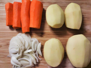 Vegetables that are peeled and sliced on a chopping board