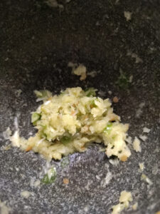 Pounded garlic, ginger and green chilli in a mortar