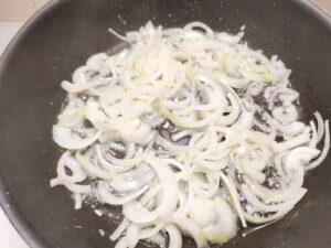 Sauteeing onion slices in a pan