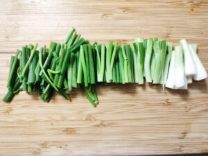 Spring onions cut in 2 inches sections on a chopping board