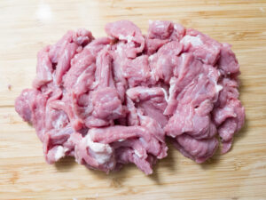 Thinly sliced chuck steak on a cutting board