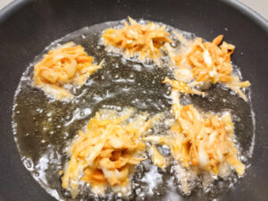 Vegetable Pakora frying in a pan