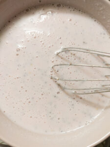 Whisking the mixture together with a whisk in a cereal bowl