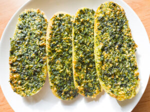 Cilantro garlic bread in the airfryer on a white serving plate (after toasting)