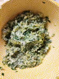 Cilantro garlic butter mix (after mixing) in a yellow bowl