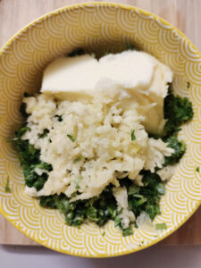 Cilantro garlic butter mix (before mixing) in a yellow bowl