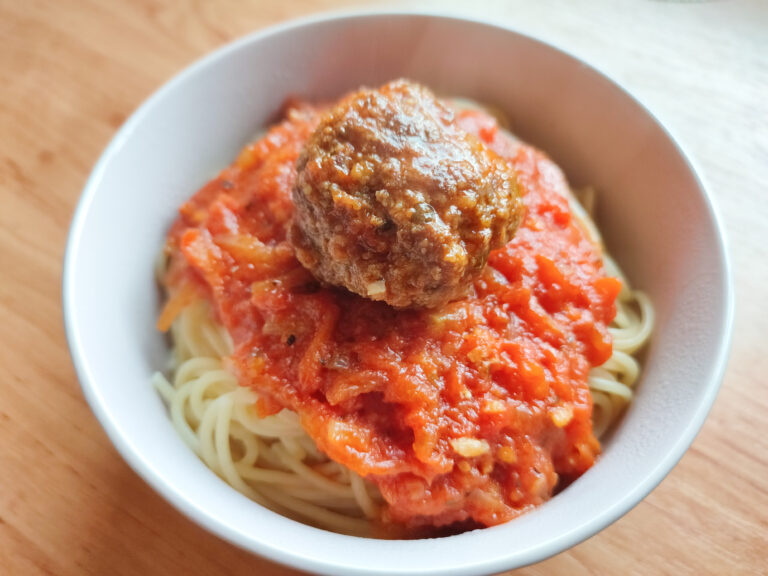 Polpette in a tomato based sauce on a bed spaghetti