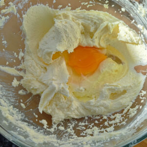 Adding first egg into creamed butter and sugar mix in the bowl