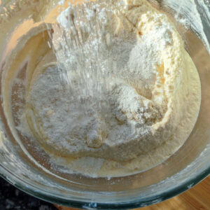 Adding in one of third self rising flour to the cake batter in the bowl