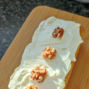 Adding reserved whole walnuts on the cake after frosting as decoration