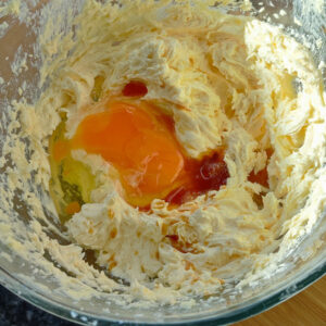 Adding second egg and vanilla extract to the cake batter in the bowl