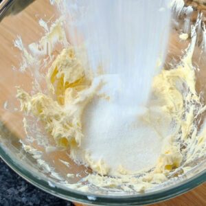 Adding sugar to creamed butter in the bowl