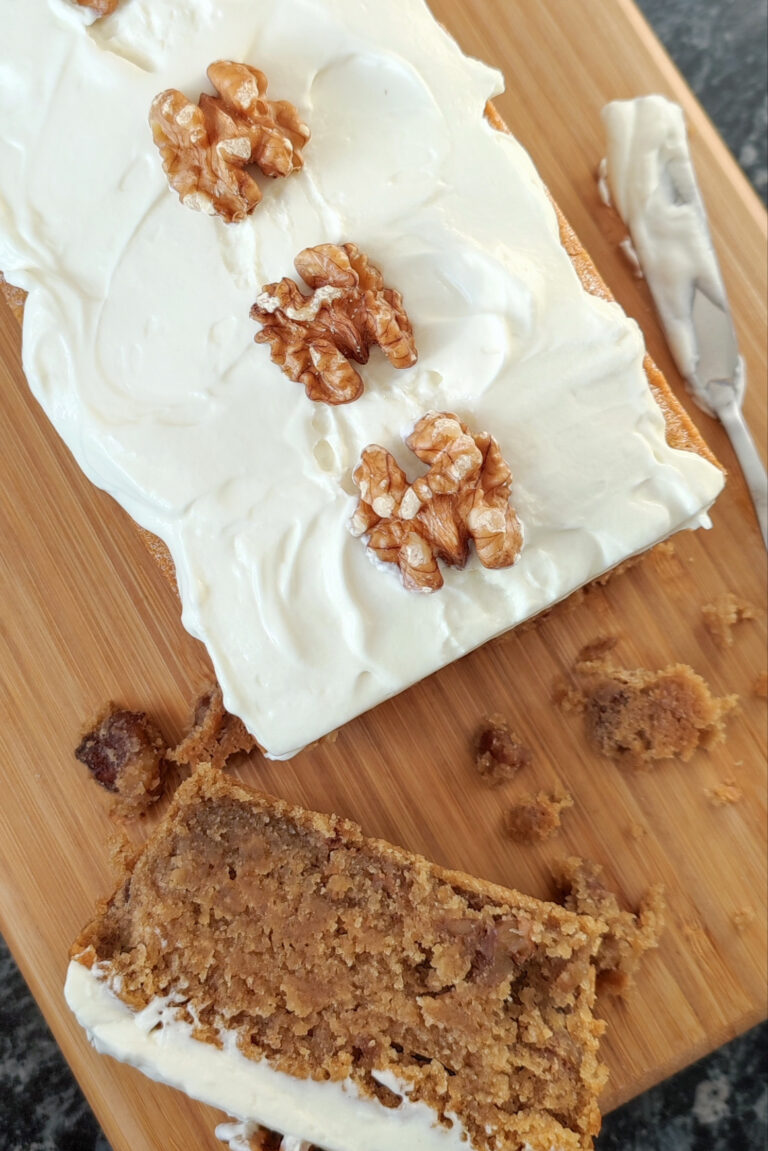 Coffee Walnut Mascarpone cake with Mascorpone Whipped Cream close up with a slice of it on the side