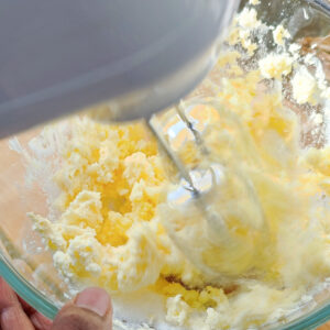 Creaming butter and sugar together in a bowl with a hand mixer