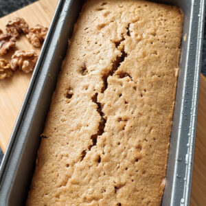 Baked Coffee Walnut Mascarpone cake in the baking mold with some walnuts on the side