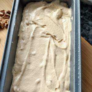 Coffee Walnut Mascarpone cake batter in the baking mold with some walnuts on the side