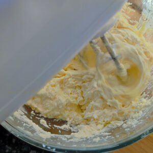 Incorporating first egg into the creamed butter and sugar in the bowl using a hand mixer