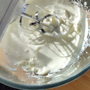 Incorporating whipped cream with mascarpone cheese in the bowl