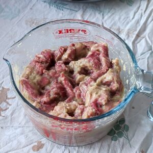 Beef coated in bulgogi marinade in a mixing bowl