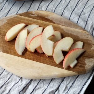 Cored and sliced apple slices on a chopping board