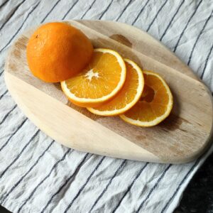 Half of on orange slices on a chopping board