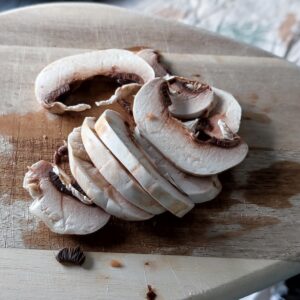 Thinly sliced mushrooms on a cutting board