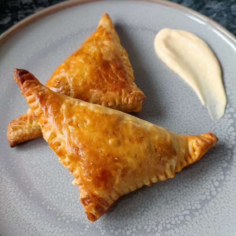 Cheesy Keema Puffs on a large gray plate with a side of smeared dollop of garlic aioli