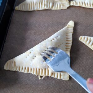 Poke small holes on the Cheesy Keema Puffs with a sharp fork before baking for air holes on the lined baking tray