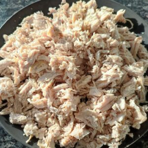 Shredded chicken on a black plate