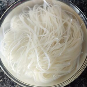 Dry noodles soaked in water in a large bowl