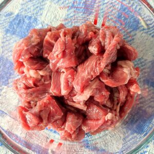 Marinating beef strips in a bowl