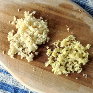 Minced garlic and ginger on a chopping board