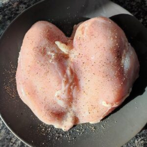 Seasoned chicken fillet on a black plate