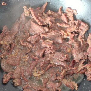 Stir fried beef strips in a wok