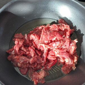 Stir frying beef meat in a wok