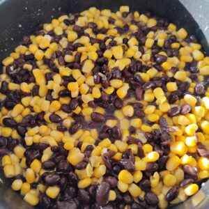 Stir frying rinsed canned corn and black beans on a pan