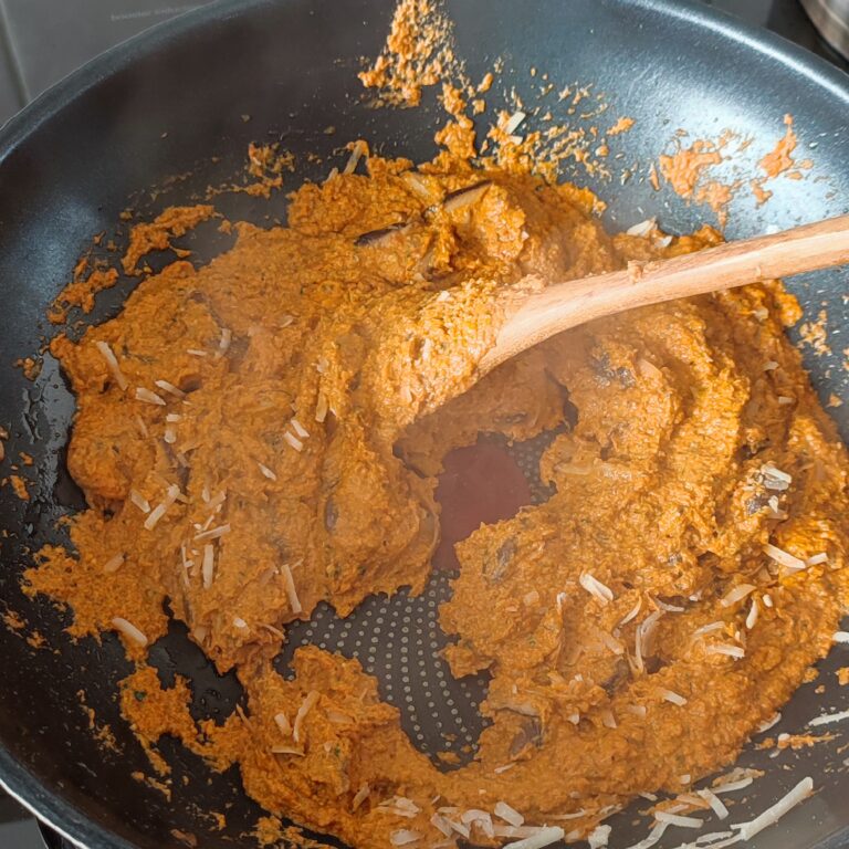 Mixing in shredded parmigiano reggiano in the pan on the stove