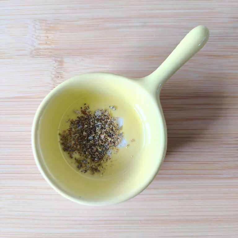 Crushed Cardamom seeds in a spice mini bowl on a working surface