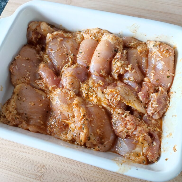 Arranged seasoned chicken in a casserole dish on a working surface