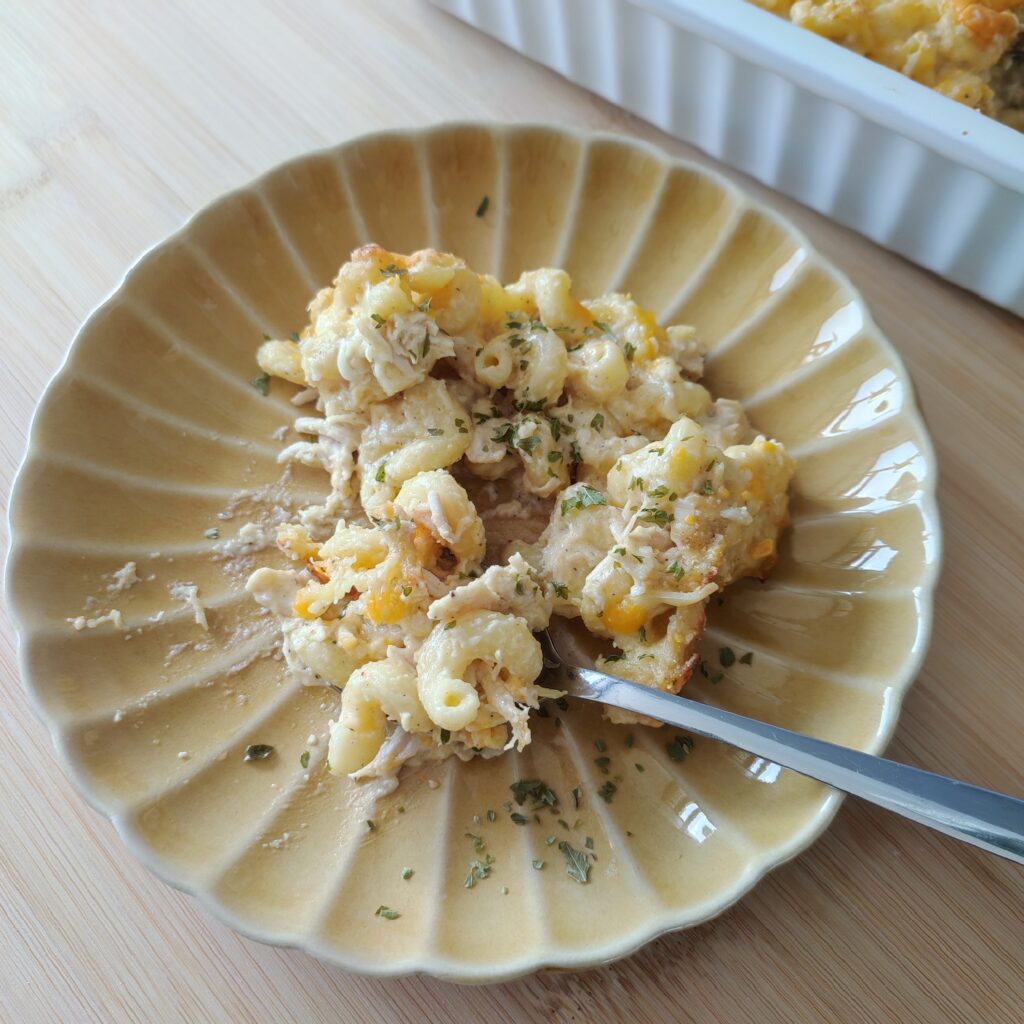 B roll 1 Classic Baked Mac & Cheese portion on a ochre ribbed plate with a spoon on a working surface