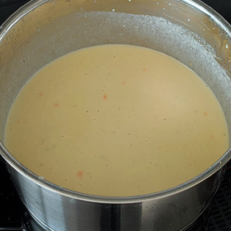 Whisked creamy melted cheese mixture in the pot