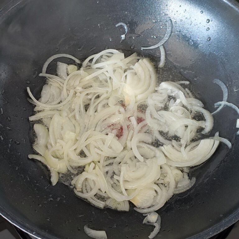 Sliced Onions sauteeing in a pan