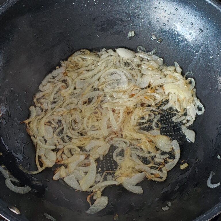 Lightly browned onion slices in a pan