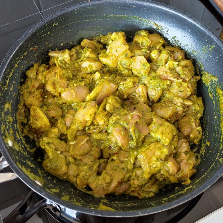 Trinidad curry chicken cooking in a pan