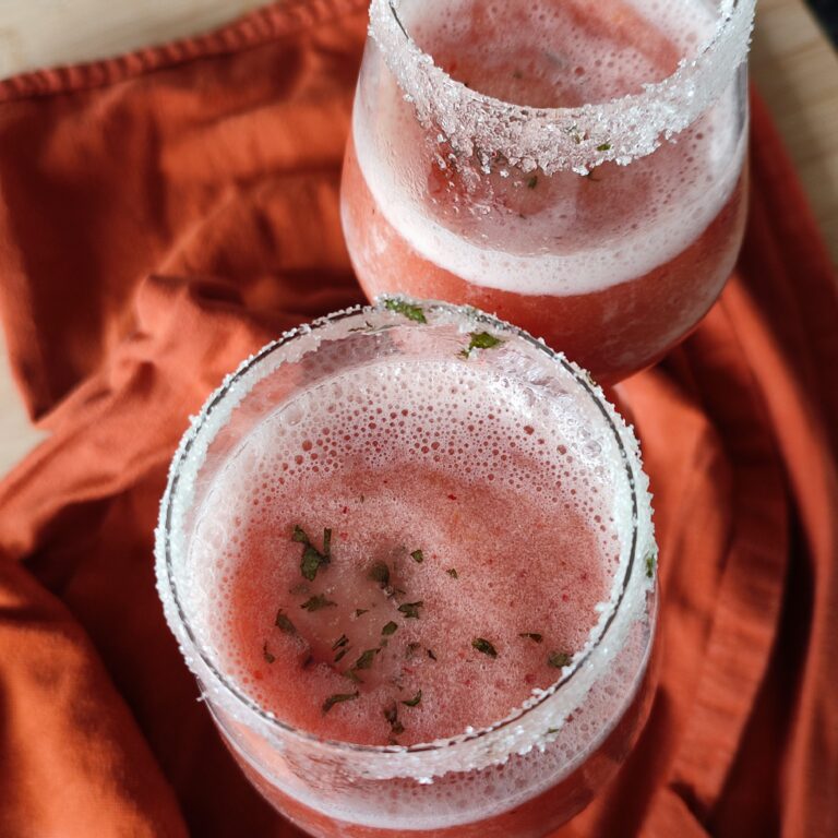 Frosé Punch in two wine glasses set on terracotta coloured cloth on a working surface