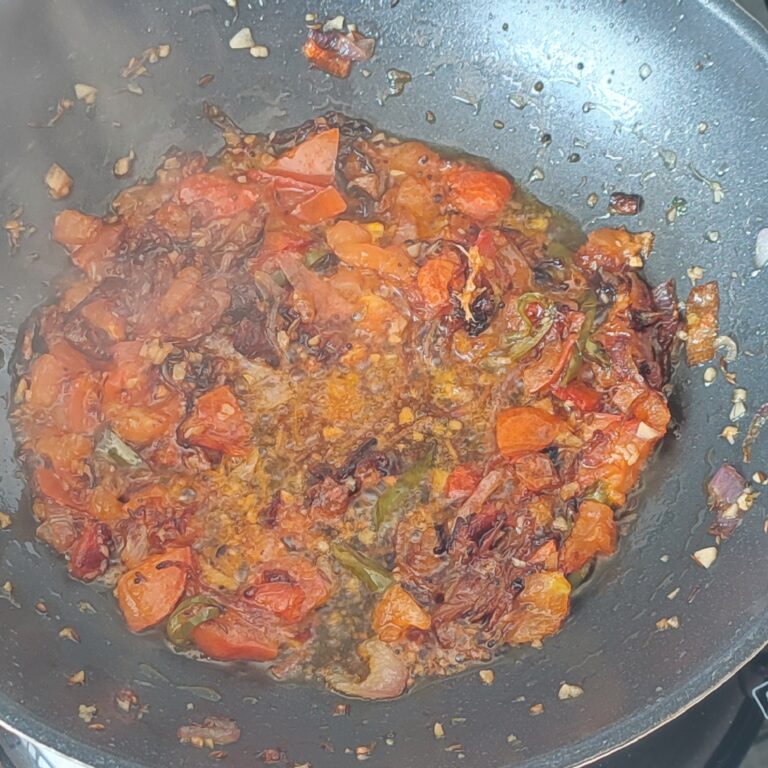 Cooked down tomatoes cooking in a largen pan