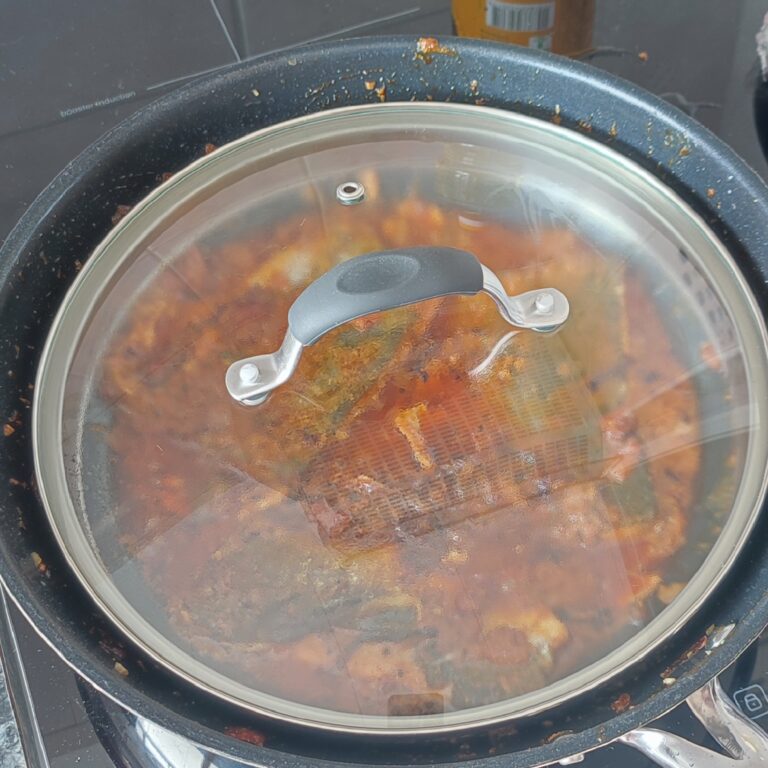 Covering pan with lid to let fish cook in a large pan