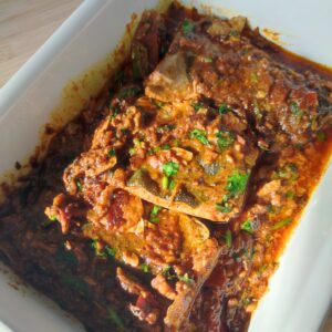 South Indian Fish Curry in a cream coloured casserole dish on a working surface